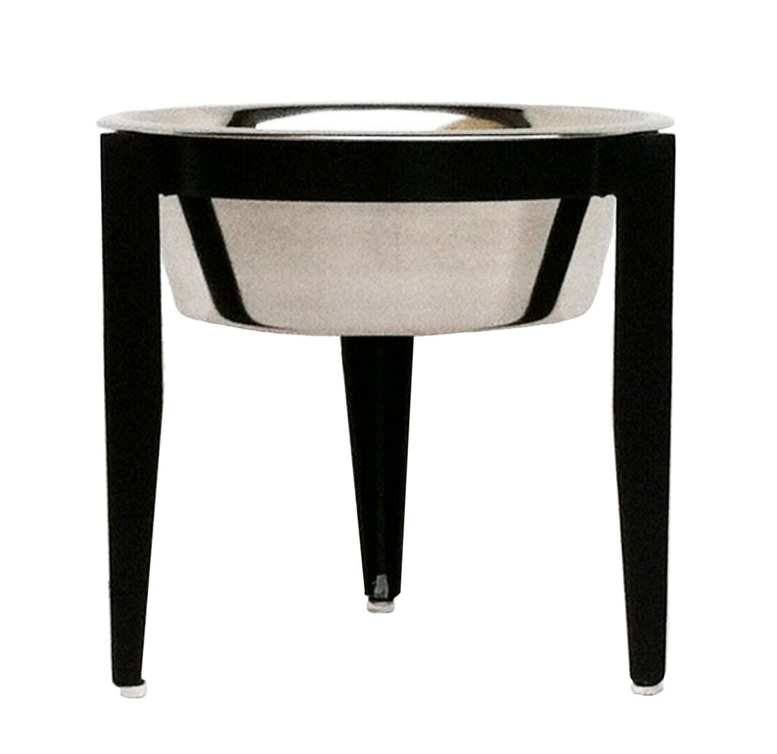 A black and white bowl sitting on top of a wooden stand.